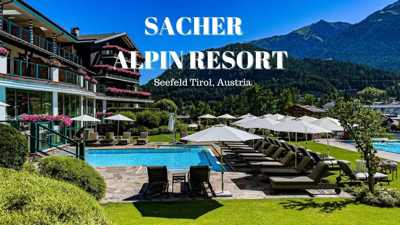 Aussenpool des Alpin Resort Sacher Seefeld mit Liegewiese, Sonnenschirmen und Alpenpanorama in Tirol.