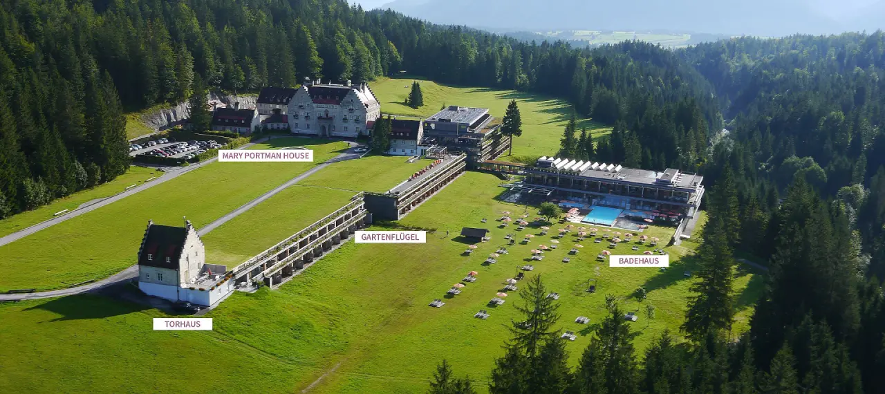 Luftaufnahme des Wellnesshotels Das Kranzbach in den bayerischen Alpen mit historischem Haupthaus und modernem Badehaus.