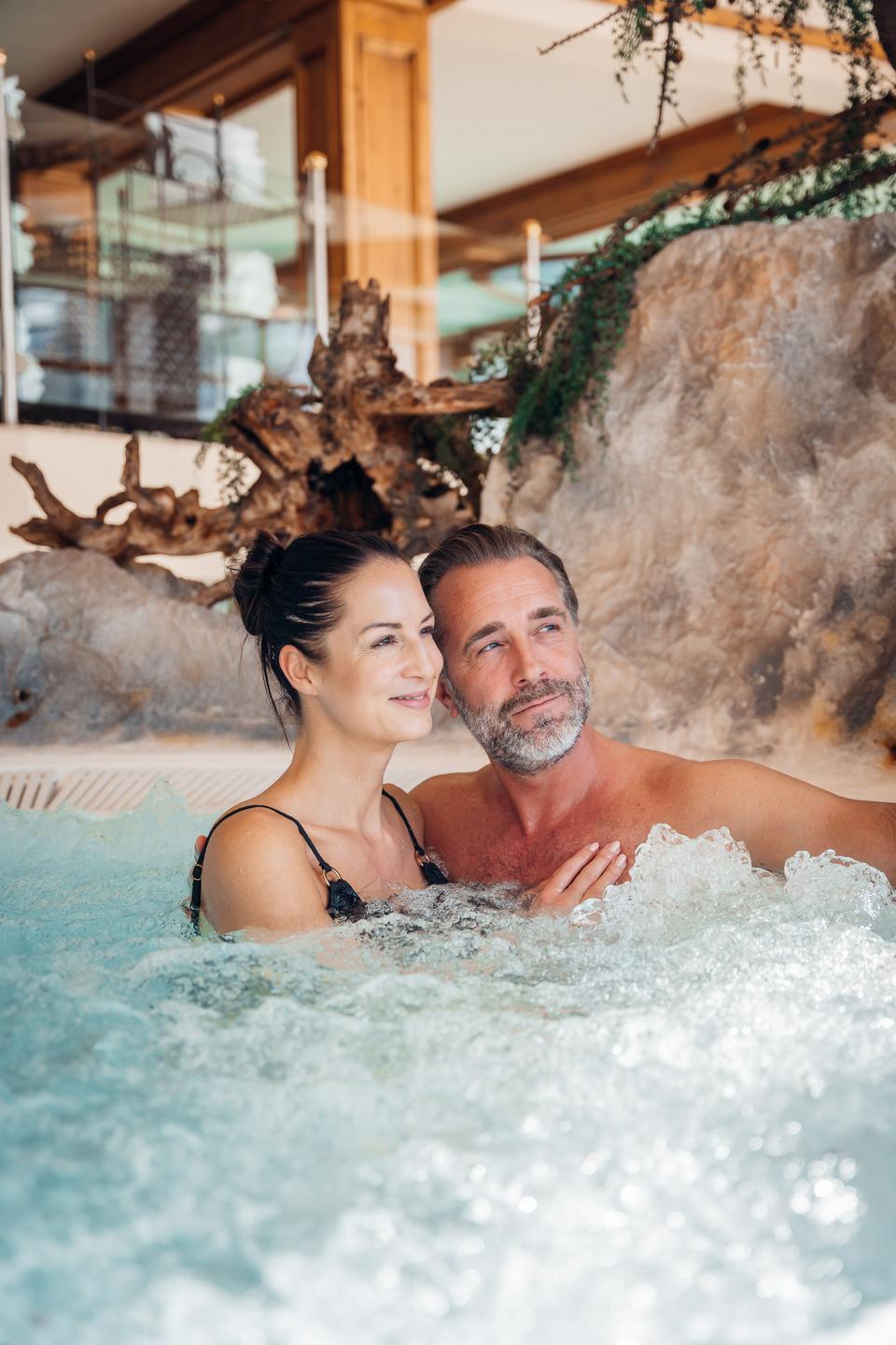 Alpen-Wellness Resort Hochfirst in Obergurgl – Glückliches Paar entspannt im warmen Whirlpool | Wellnesshotel Tirol