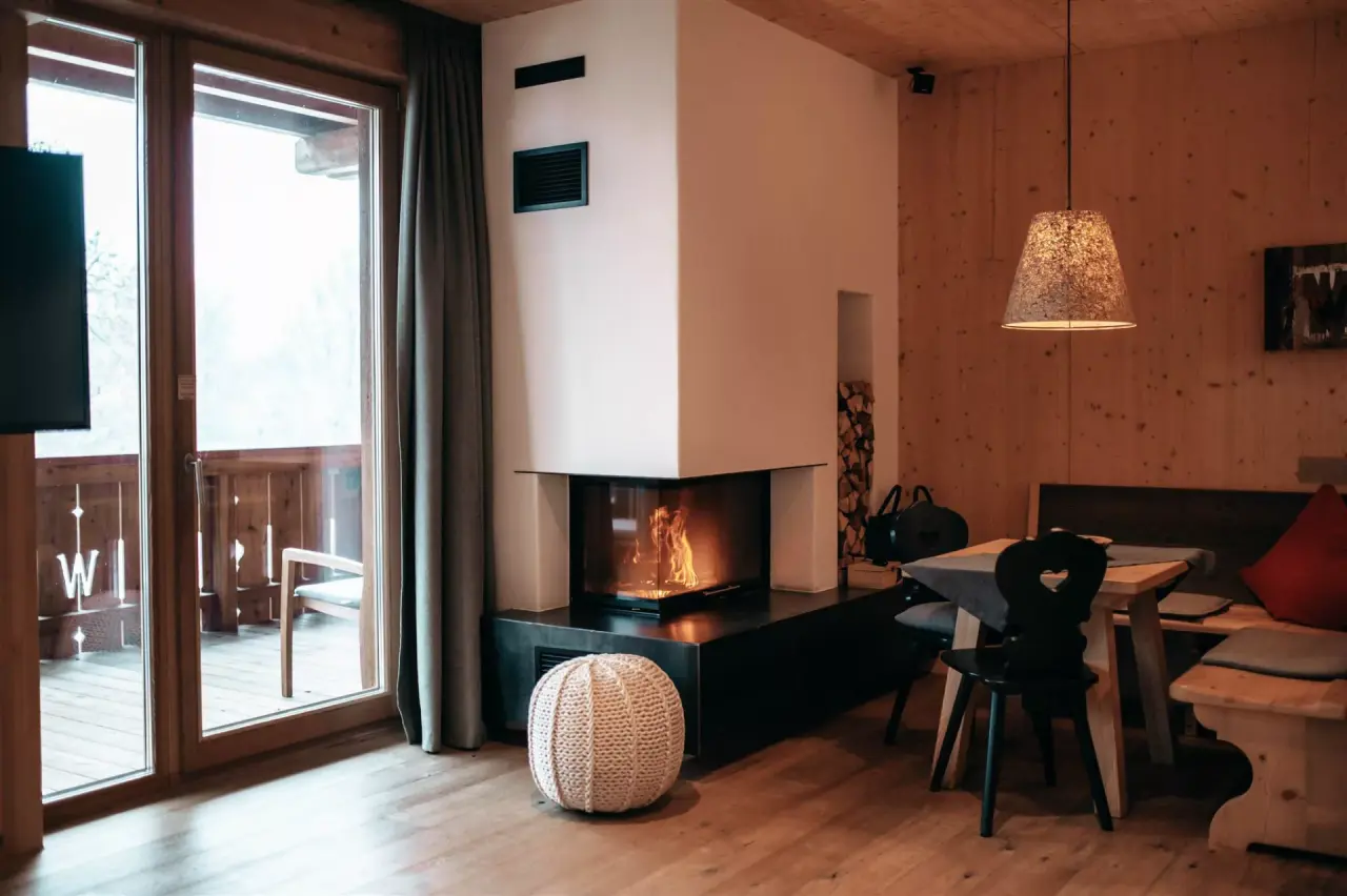Gemütliches Hotelzimmer mit Kamin, Holzelementen und Balkon im Hotel WERDENFELSEREI.