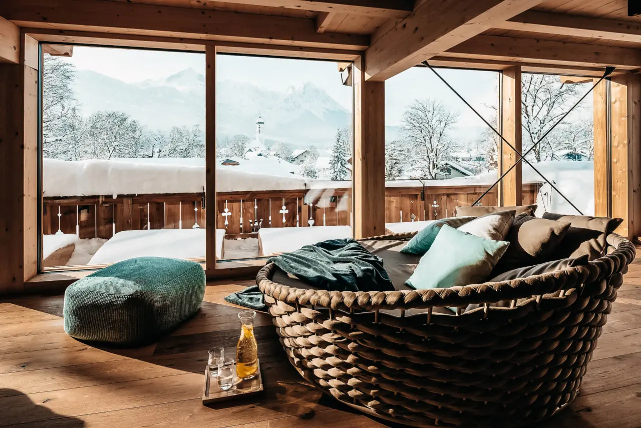 Gemütlicher Entspannungsbereich mit Tagesbett und Bergblick im Winter im Hotel WERDENFELSEREI
