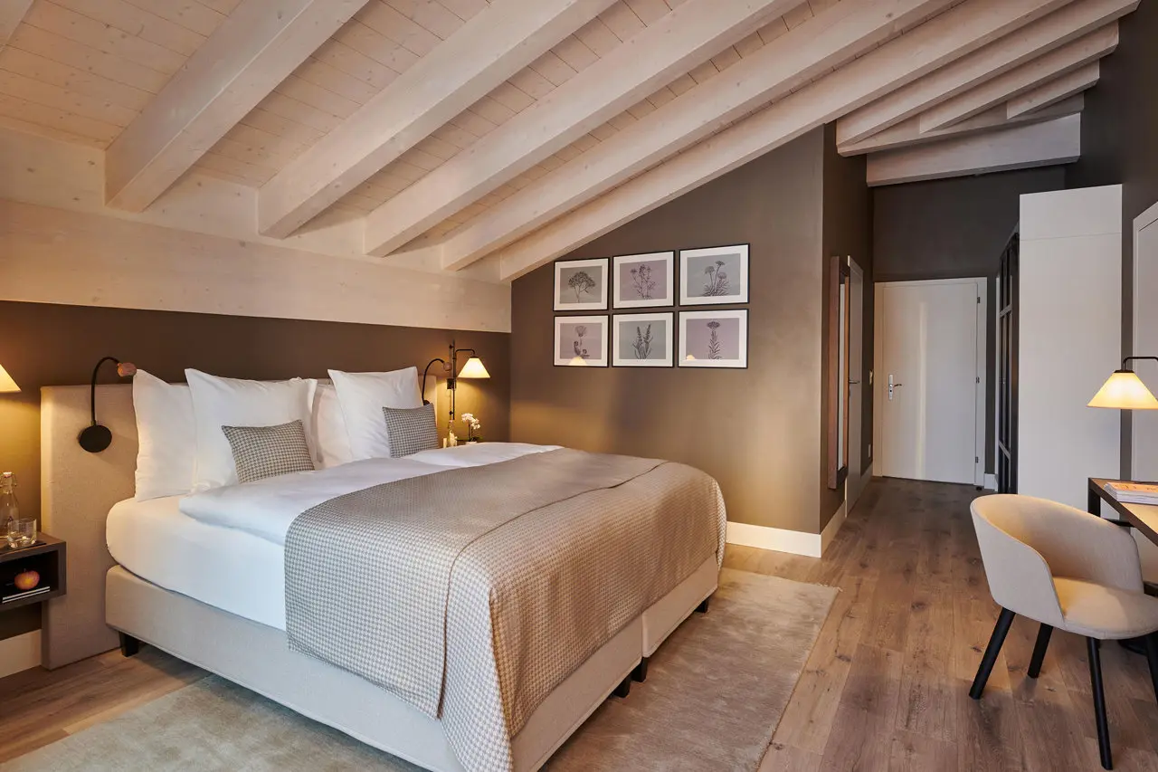 Modernes Doppelzimmer mit Holzbalkendecke und gemütlicher Einrichtung im SchlossHotel Zermatt.