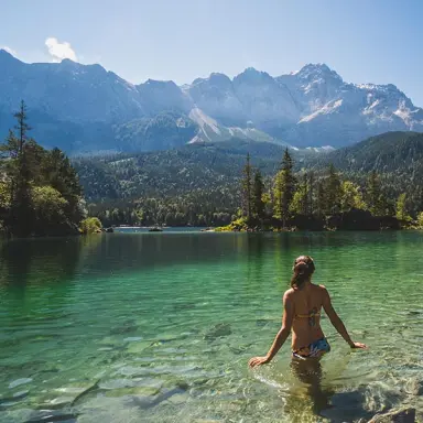 Frau genießt das klare Wasser des Eibsees mit majestätischem Zugspitz-Panorama. Ideal für einen Wellness-Urlaub im Hotel Zugspitze.