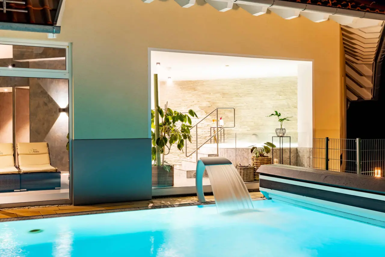 Beheizter Aussenpool mit Wasserfall und Blick auf den Whirlpool im Best Western Plus Parkhotel Maximilian.