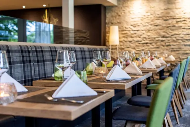 Elegantes Restaurant mit modern gedeckten Tischen und gemütlicher Sitzbank im Best Western Plus Parkhotel Maximilian.