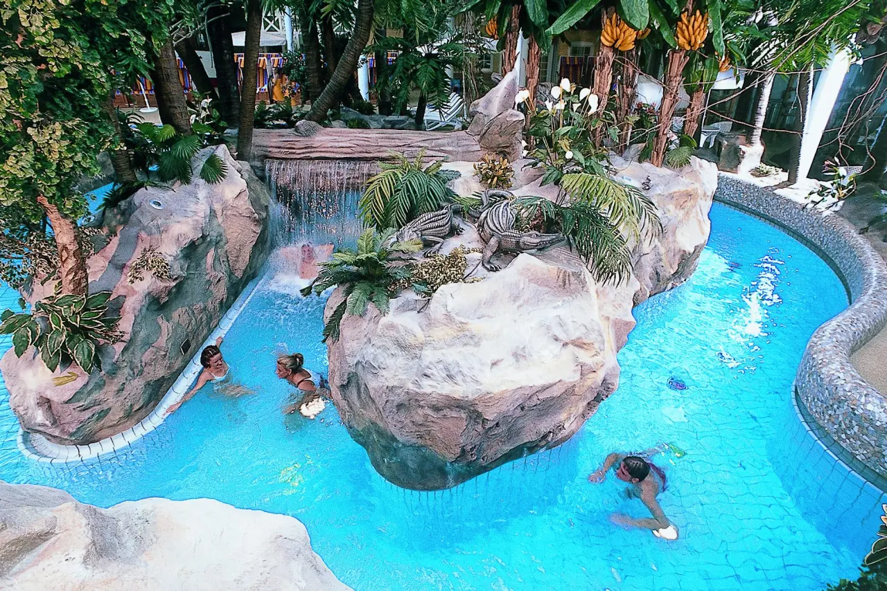 Tropische Badelandschaft mit Wasserfall und Schwimmbecken im Wyndham Hotel Stralsund HanseDom.