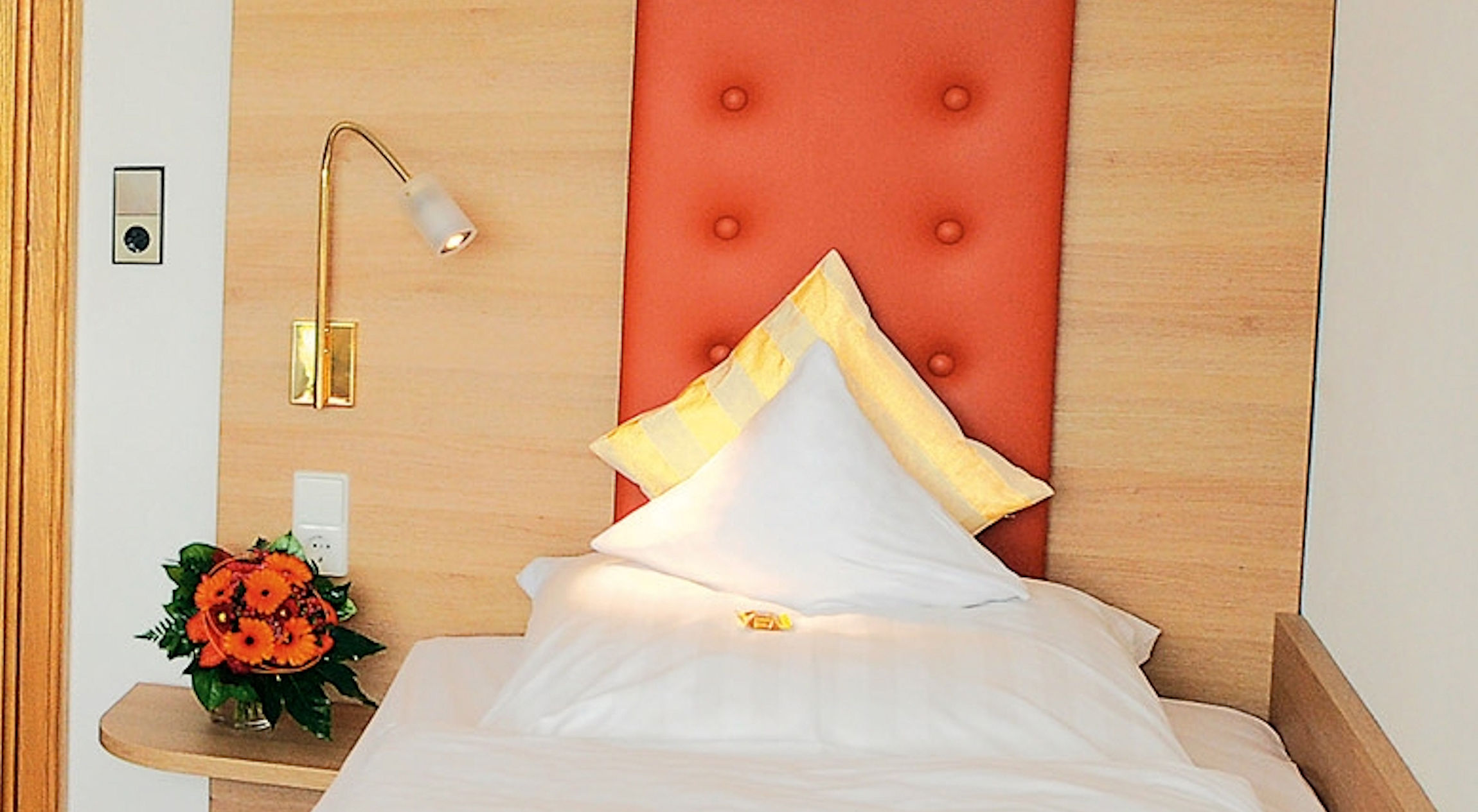 Schwarzwaldhotel Oberwiesenhof in Seewald – Detailansicht eines Hotelbettes mit Blumenstrauß | Wellnesshotel Schwarzwald