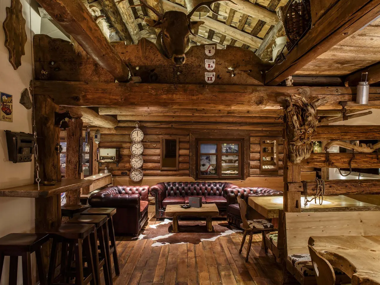Alpiner Stil Lounge und Restaurant im Sporthotel Grandau mit Holzbalken, Ledersofas und traditioneller Einrichtung.