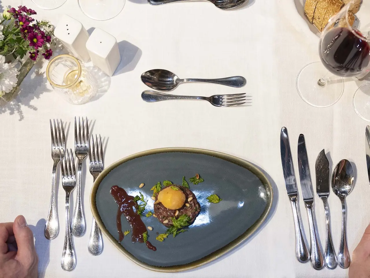 Fein angerichtetes Gericht mit Tatar und Eigelb im Restaurant des Sporthotels Grandau.