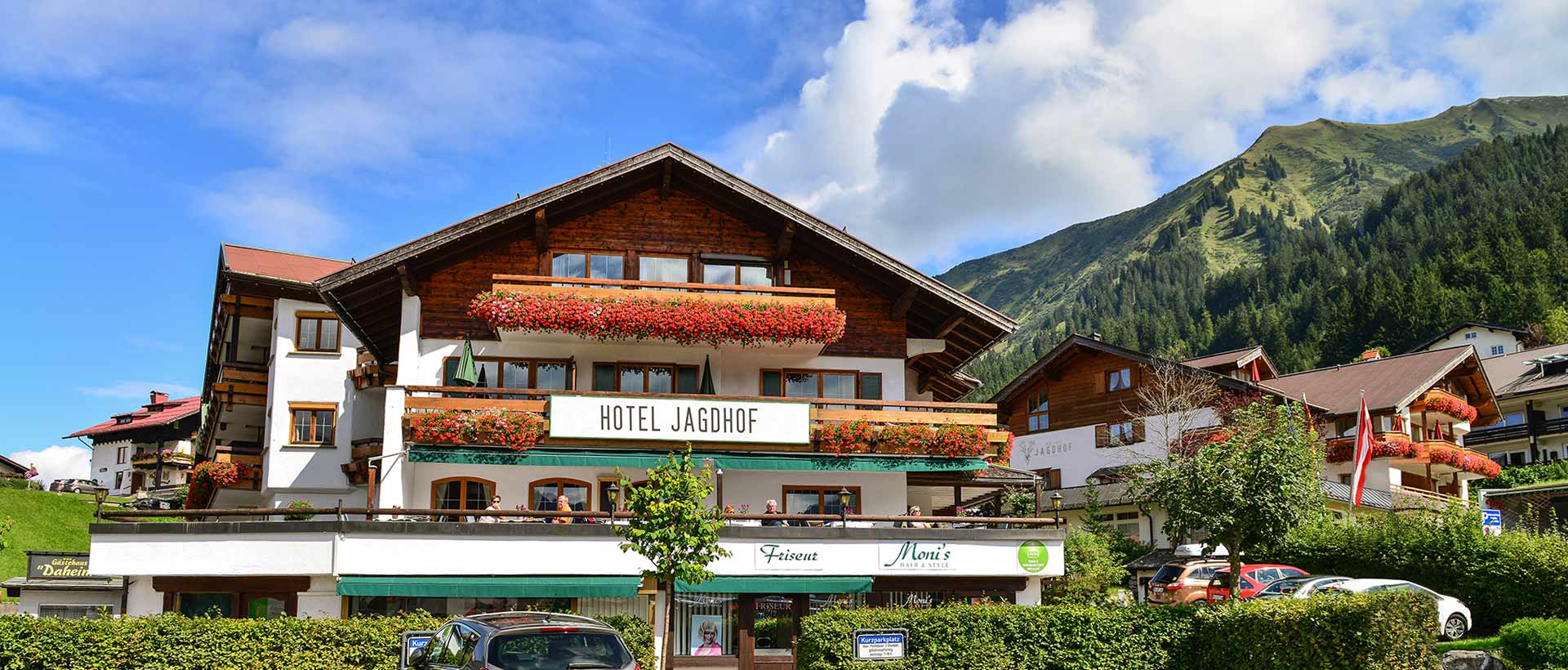 Hotel Jagdhof in Riezlern – Traditionelles Hotelgebäude im Sommer mit Bergkulisse | Wellnesshotel Kleinwalsertal