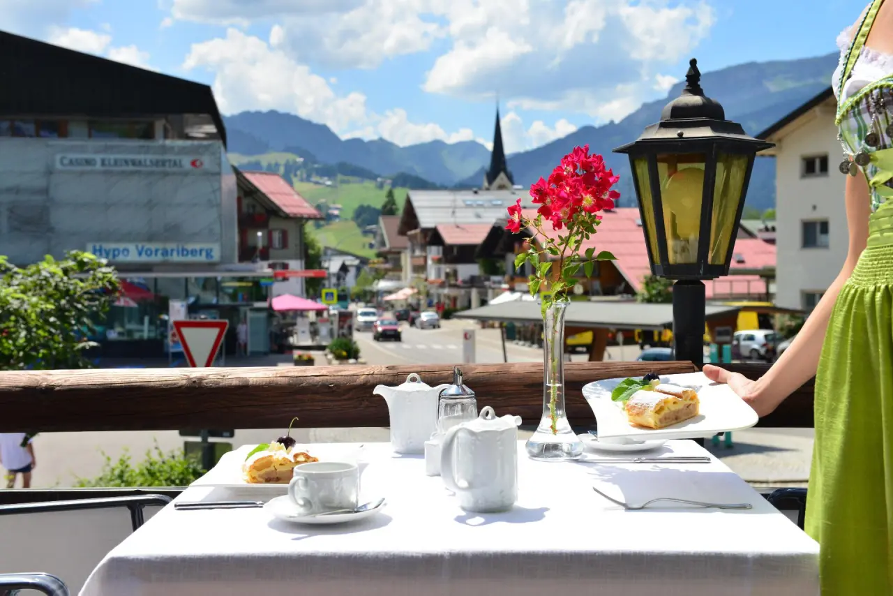 Hotel Jagdhof in Riezlern – Frühstück auf der Terrasse mit Blick auf die Dorfstraße | Wellnesshotel Kleinwalsertal