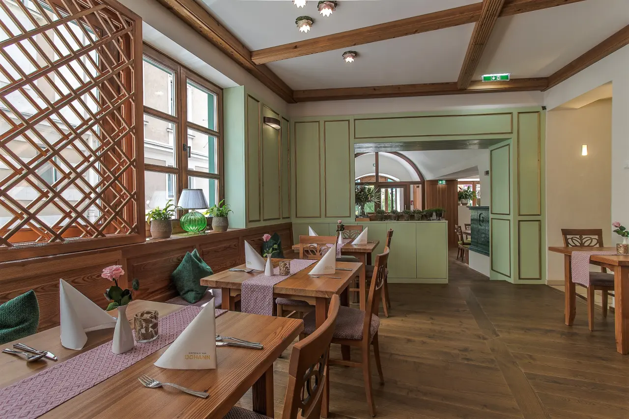 Gemütliches Restaurant 'Wirtshaus + Bar Johann' im Spa Hotel Erzherzog Johann mit Holztischen und traditionellem Ambiente.