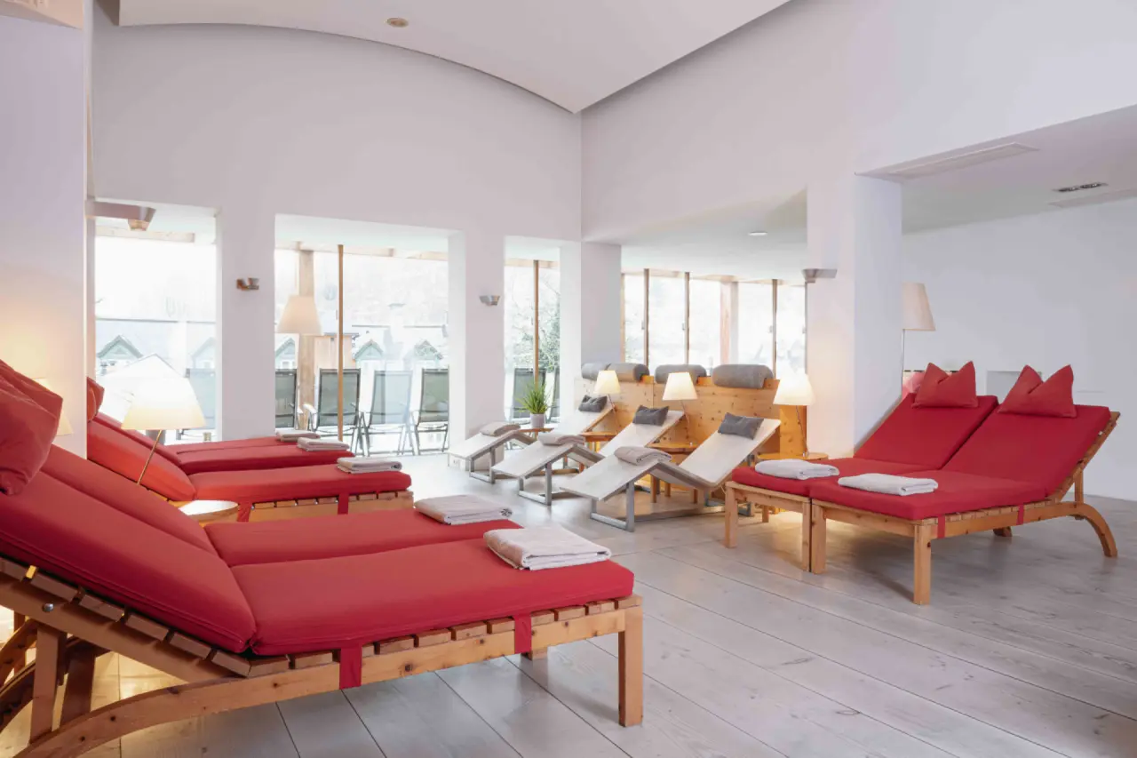 Heller Entspannungsbereich mit roten Liegen und großen Fenstern im Spa Hotel Erzherzog Johann