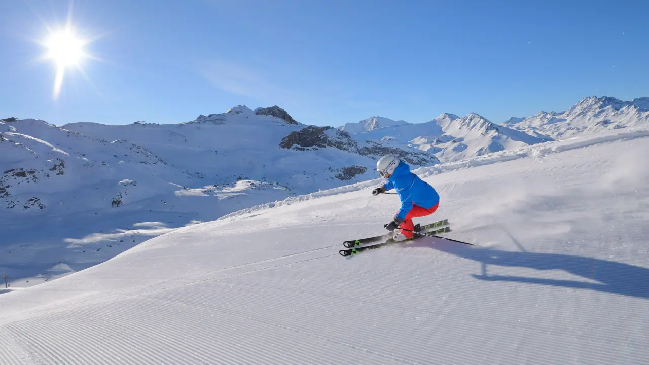 Skifahrer auf frisch präparierter Piste mit strahlendem Sonnenschein und Bergpanorama im Skigebiet des Hotel Salnerhof.
