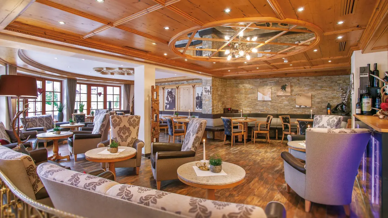 Gemütliche Lobby-Lounge mit Holzelementen, Steinwand und bequemen Sitzgelegenheiten im Hotel Salnerhof.