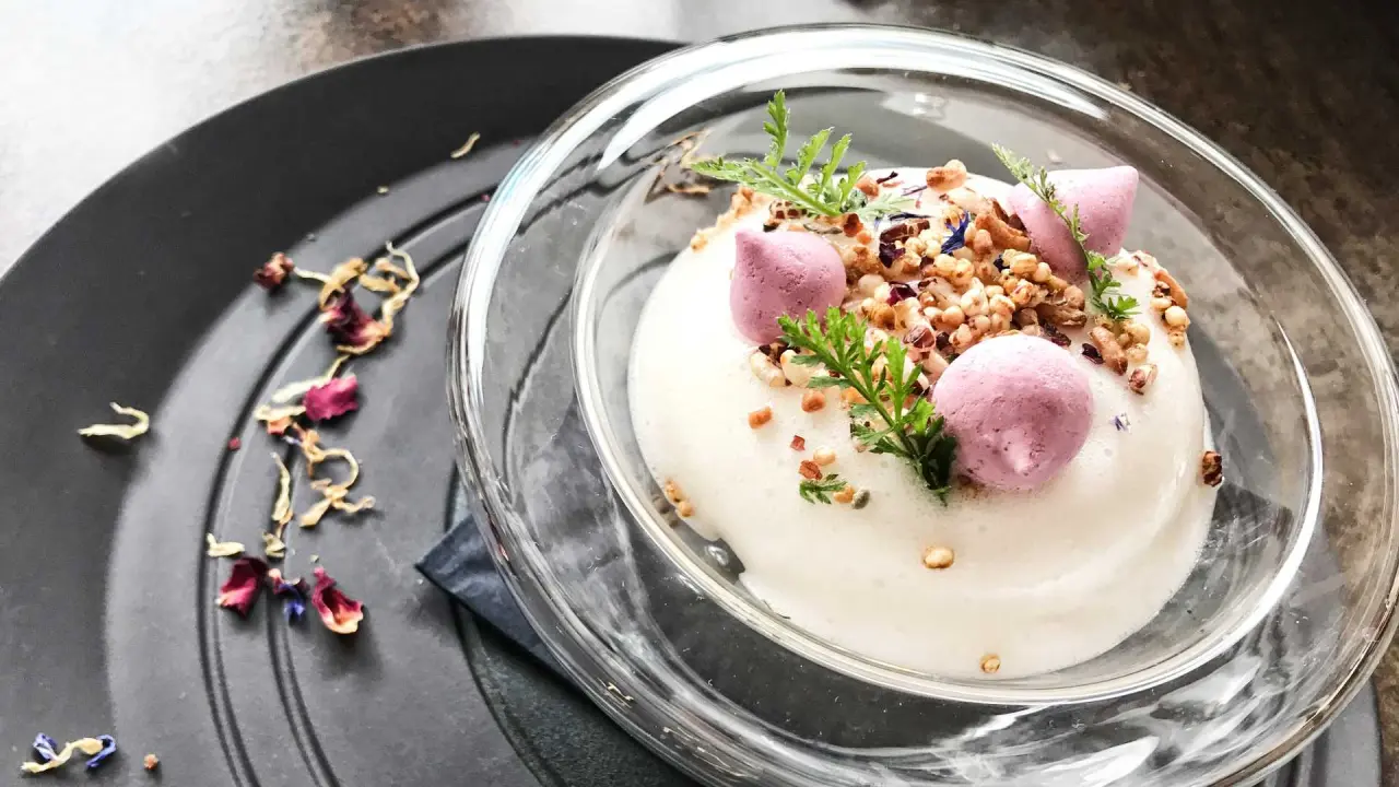 Ansprechend angerichtetes Dessert mit weißem Schaum, rosa Baiser und Nüssen im Hotel Salnerhof.