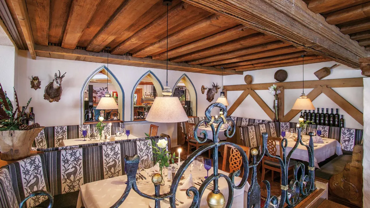 Gemütliches Restaurant im traditionellen Stil mit Holzbalkendecke und festlich gedeckten Tischen im Hotel Salnerhof.