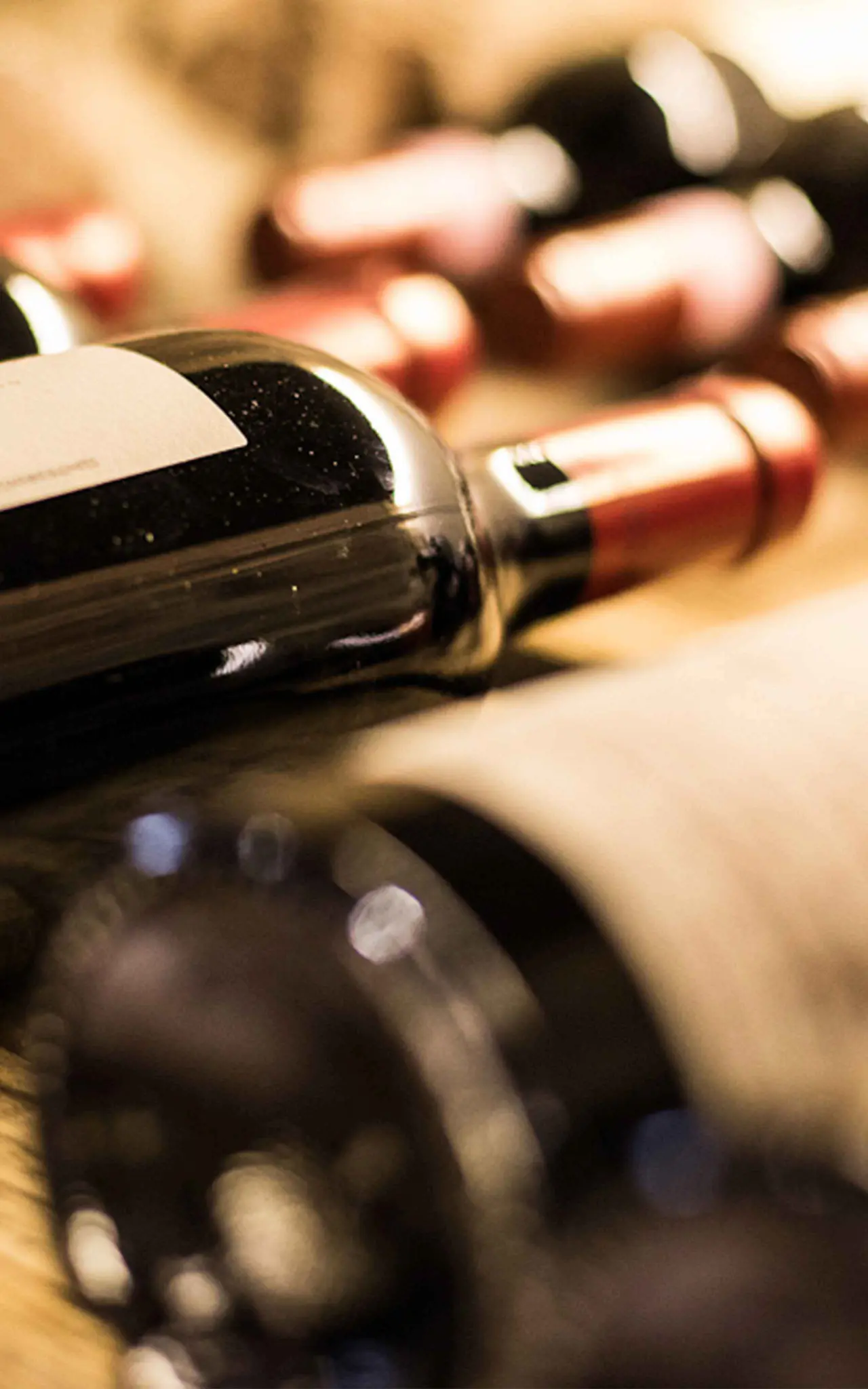 Nahaufnahme von Weinflaschen im Selfness- & Genuss-Hotel Ritzlerhof, deutet auf kulinarisches Angebot hin.