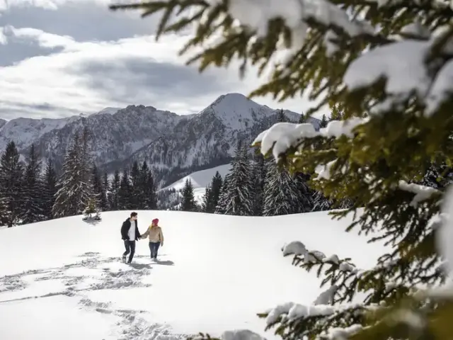 Paar beim Winterwandern in verschneiter Berglandschaft des LEBE FREI Hotel DER LÖWE
