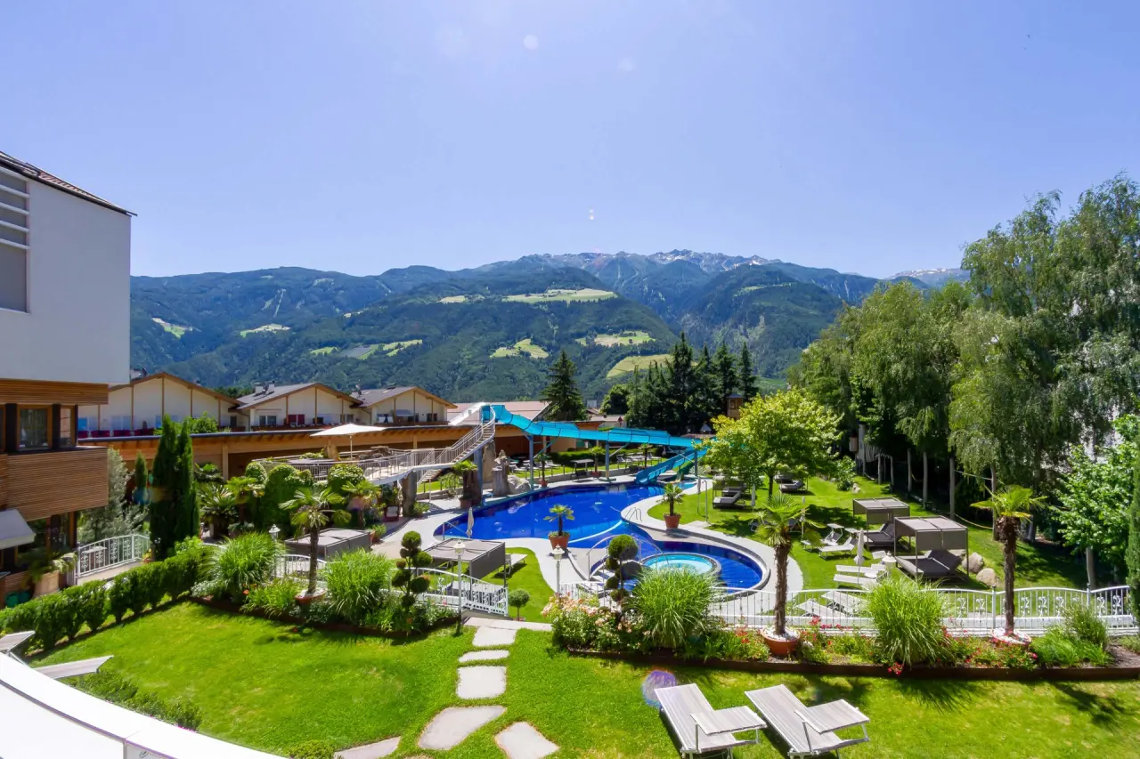 TYROL family retreat in Naturns – Außenpool mit Wasserrutsche und Bergblick | Wellnesshotel Südtirol