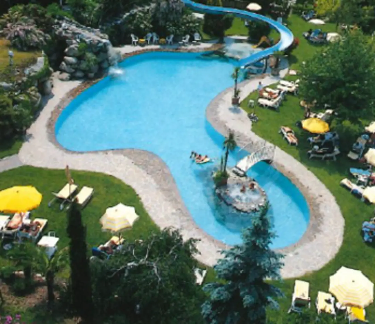 TYROL family retreat in Naturns – Großer Außenpool mit Wasserrutsche und Liegewiese | Wellnesshotel Südtirol