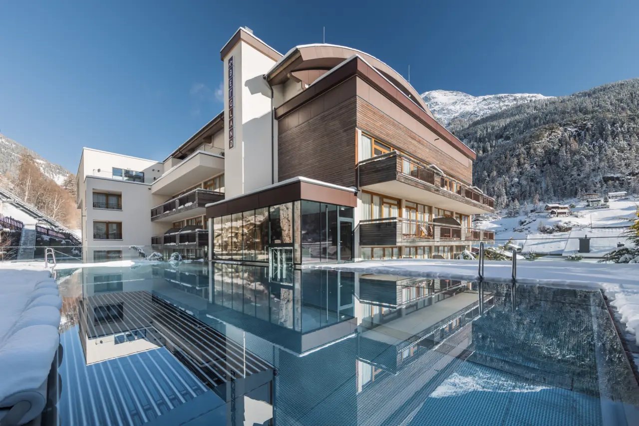 Beheizter Infinity-Aussenpool mit Blick auf das Bergland Hotel Sölden und die verschneite Alpenlandschaft im Winter.