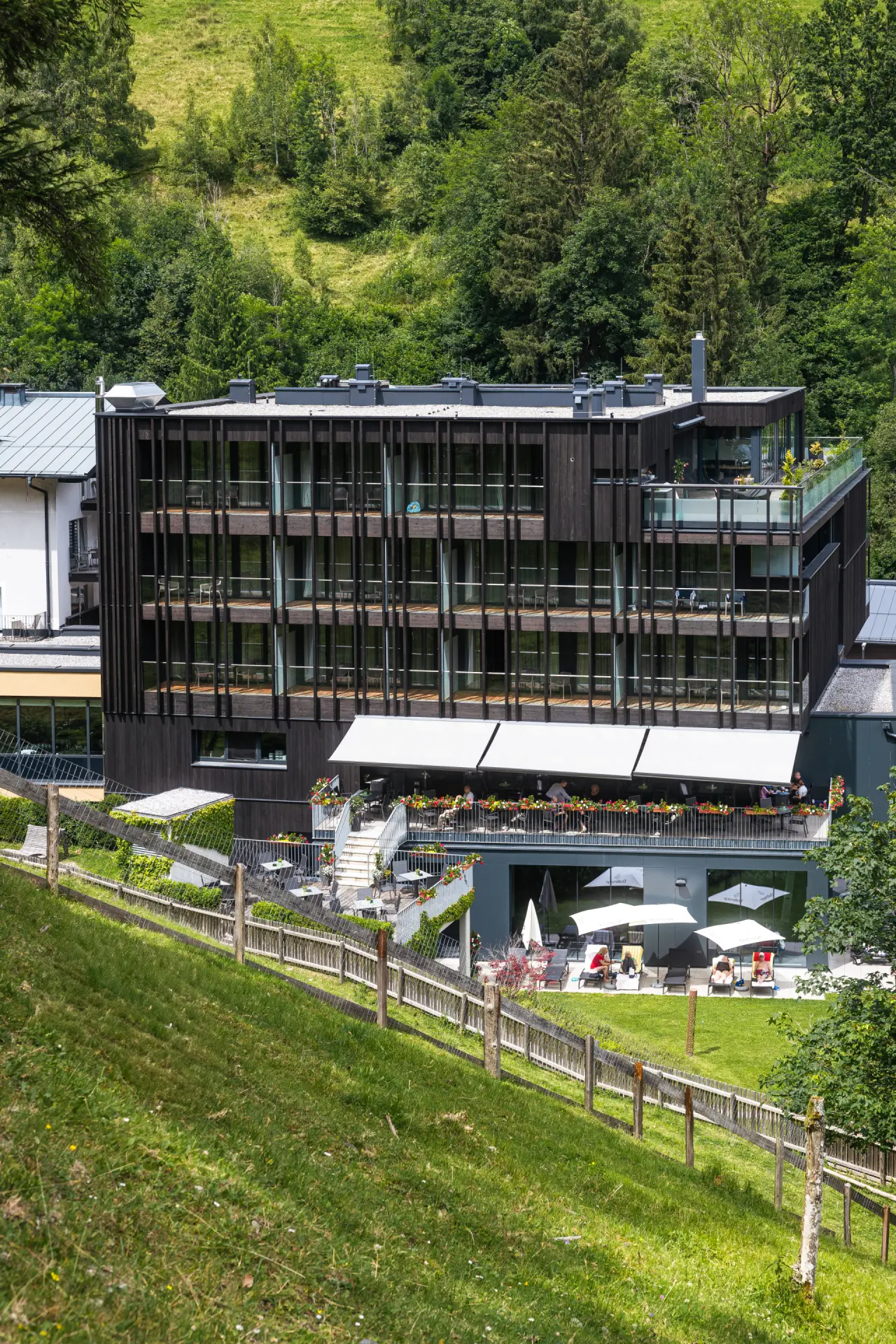 Hotel Der Waldhof in Zell am See – Hotelgebäude eingebettet in grüne Hügellandschaft | Wellnesshotel Salzburger Land