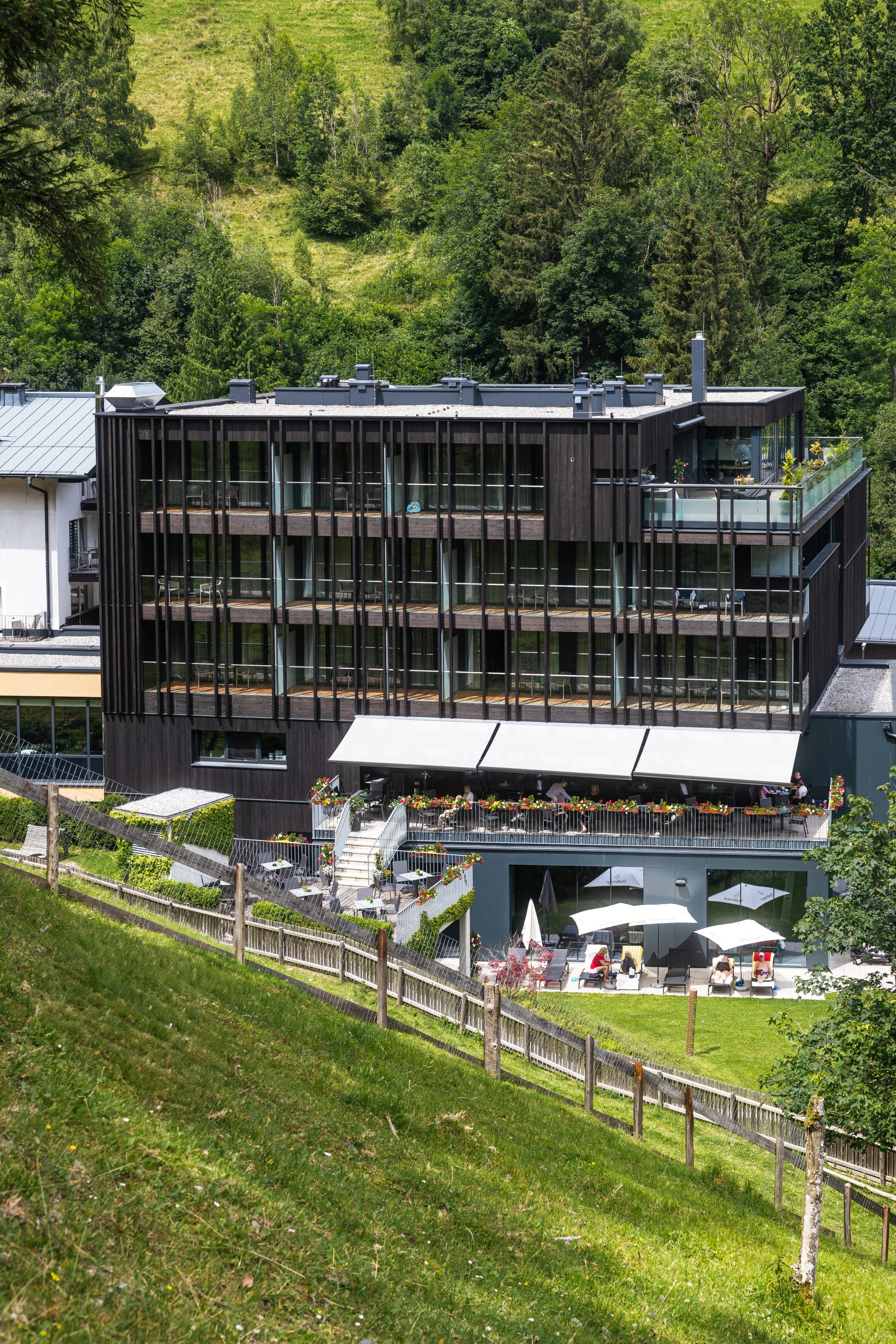 Hotel Der Waldhof in Zell am See – Hotelgebäude eingebettet in grüne Hügellandschaft | Wellnesshotel Salzburger Land