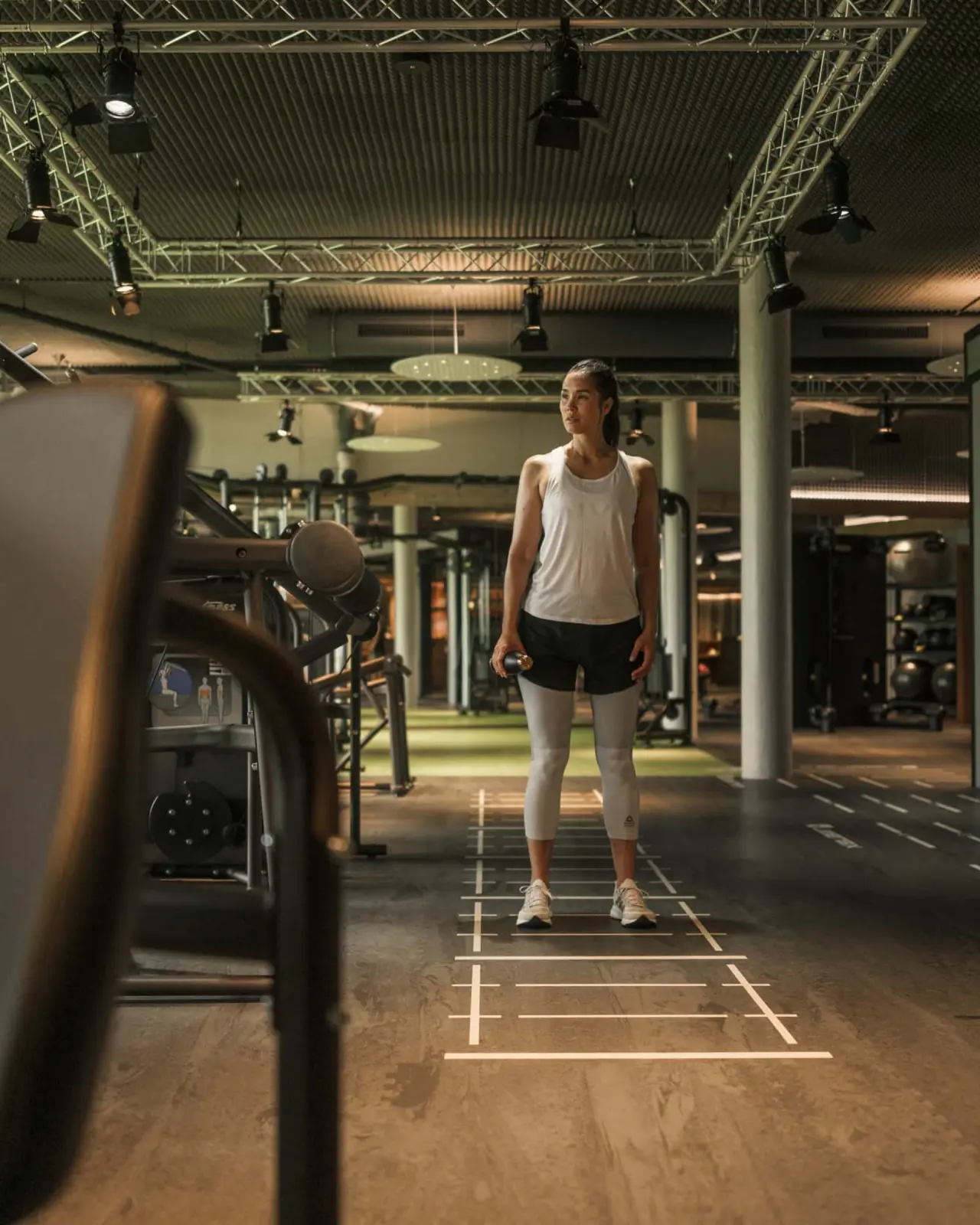 Moderne Fitnessbereich im Hotel Mohr Life Resort mit einer Person bereit zum Training und hochwertigen Geräten.