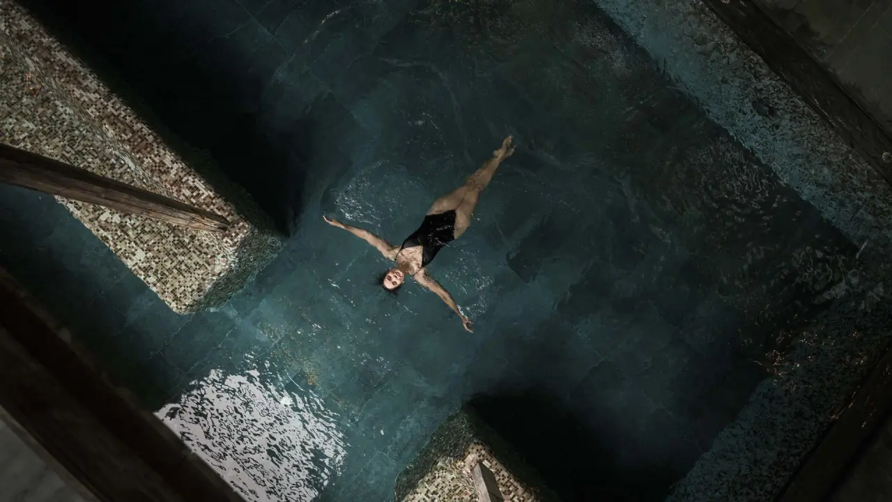 Gastin entspannt schwebend im dunklen Innenpool des Hotel Mohr Life Resort. Ruhige Atmosphäre im Wellnessbereich.