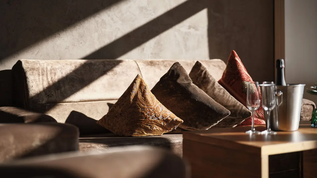 Luxuriöse Sitzecke mit Samtkissen und Champagner im Hotel Mohr Life Resort für entspannte Momente.