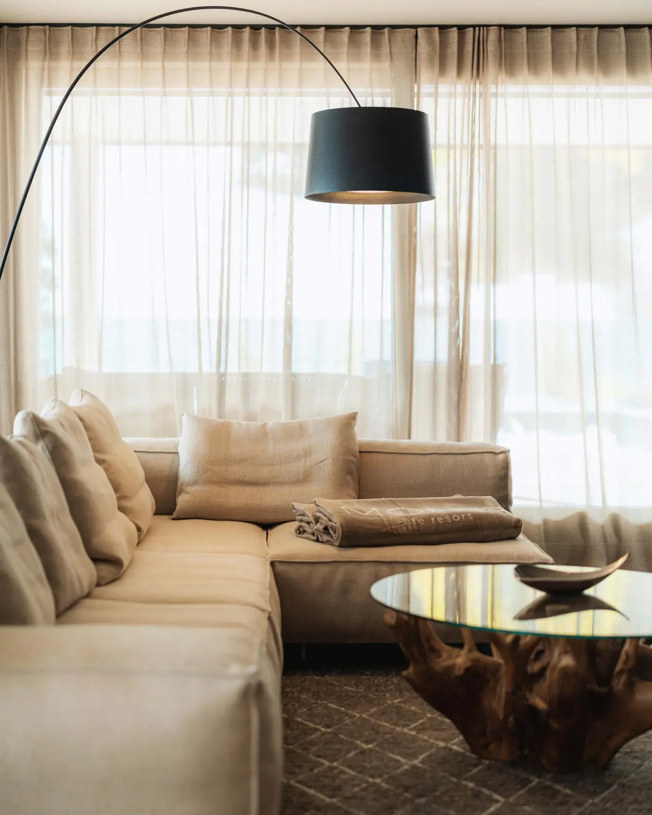 Gemütlicher Wohnbereich mit Ecksofa, modernem Couchtisch und Stehlampe im Hotel Mohr Life Resort.