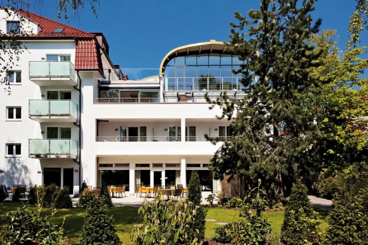 Moderne Aussenansicht des Ringhotel Strandblick mit Terrassen und Gartenanlage unter blauem Himmel.