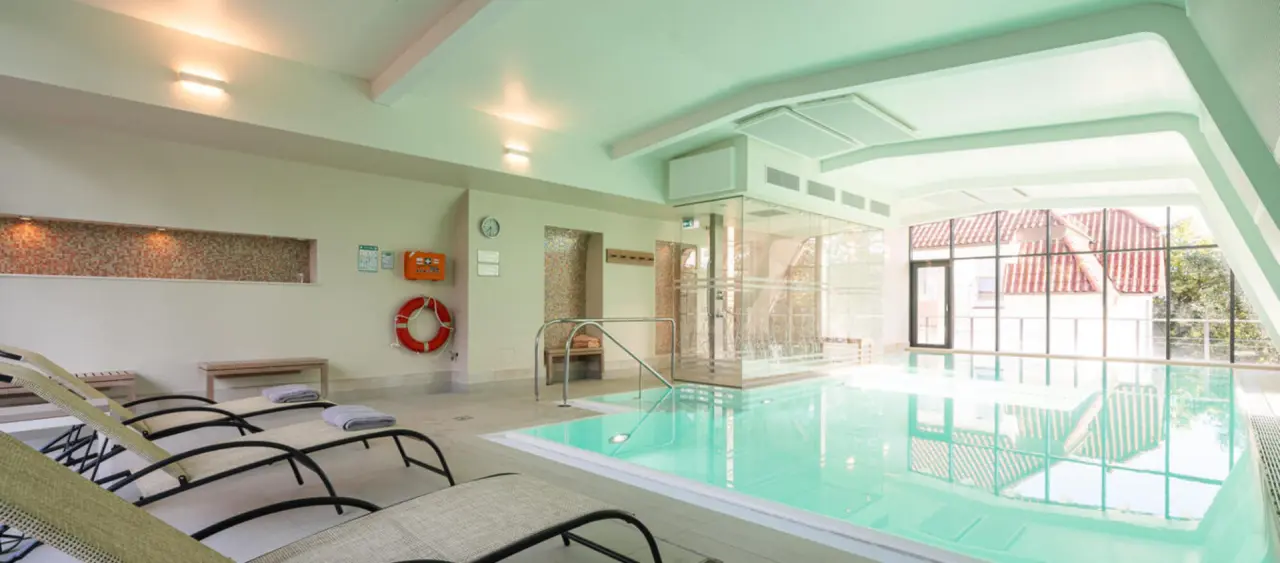Heller Innenpool mit Liegestühlen und Tageslicht im Wellnessbereich des Ringhotel Strandblick