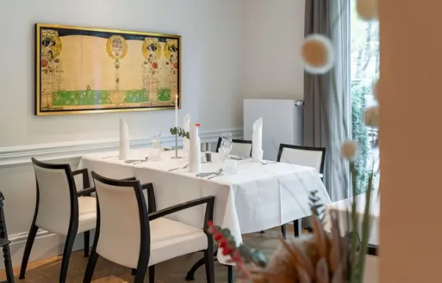 Gedeckter Tisch im eleganten Restaurant des Ringhotel Strandblick mit Kunstwerk an der Wand.