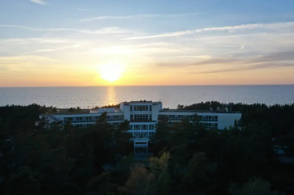 Strandhotel Fischland bei Sonnenuntergang mit Blick auf die Ostsee und umliegende Kiefernwälder.
