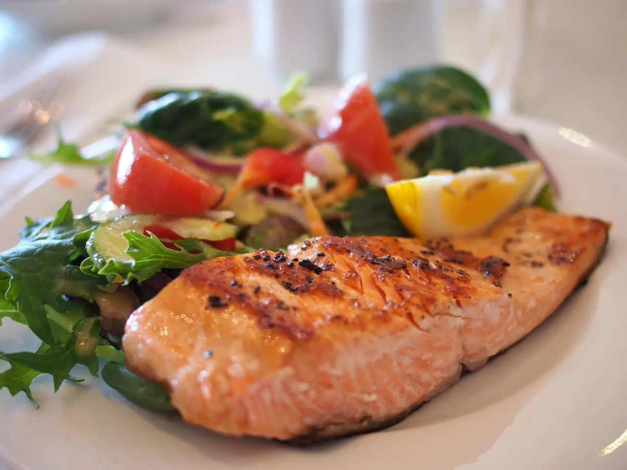 Gegrillter Lachs mit frischem Salat und Zitrone im Restaurant des Strandhotel Fischland.