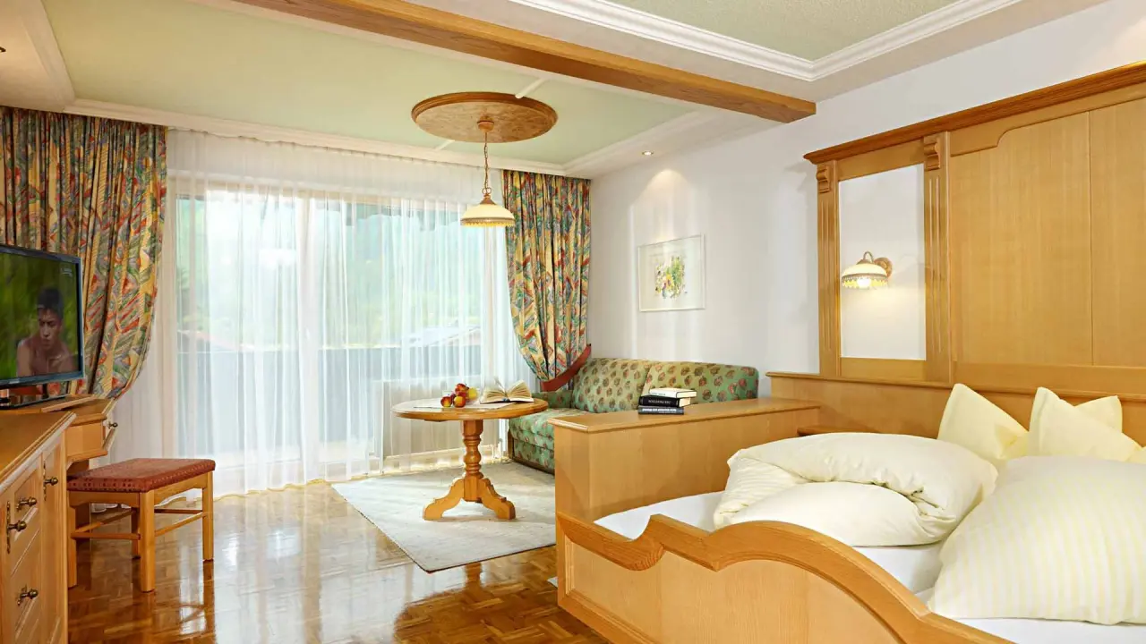 Gemütliches Doppelzimmer mit Balkon und Sitzbereich im Hirschen Wohlfühlhotel.