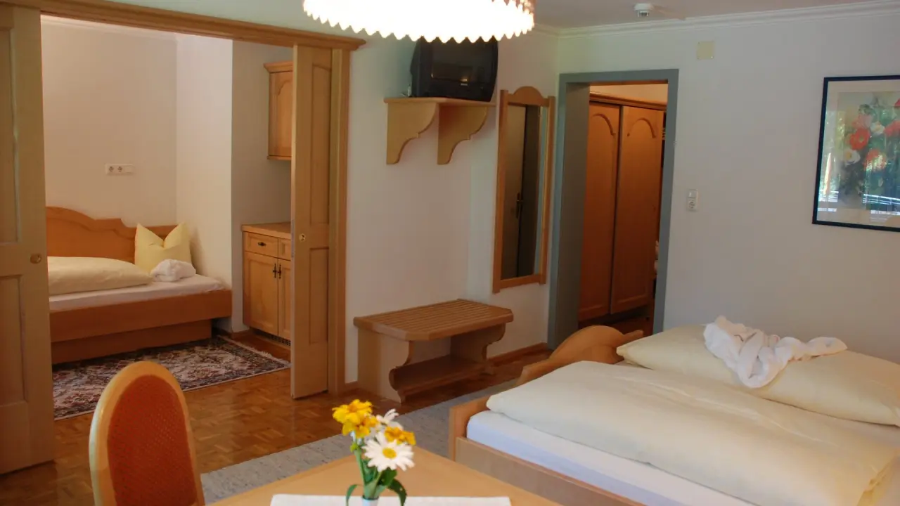 Gemütliches Doppelzimmer mit Holzelementen und separatem Schlafbereich im Hirschen Wohlfühlhotel.