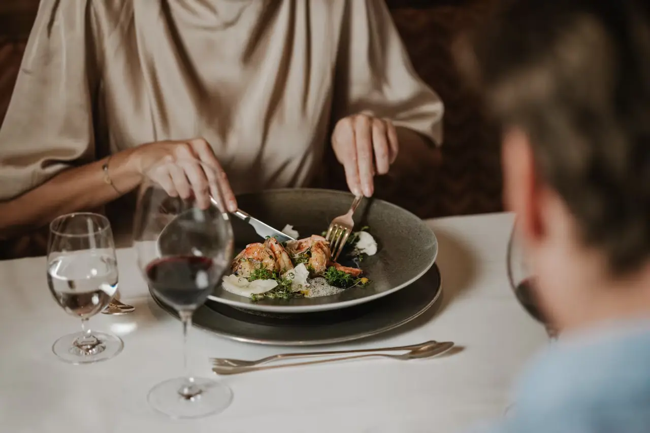Schlosshotel Fiss in Fiss – Gast genießt ein exquisites Gericht mit Garnelen im Hotelrestaurant | Wellnesshotel Tirol