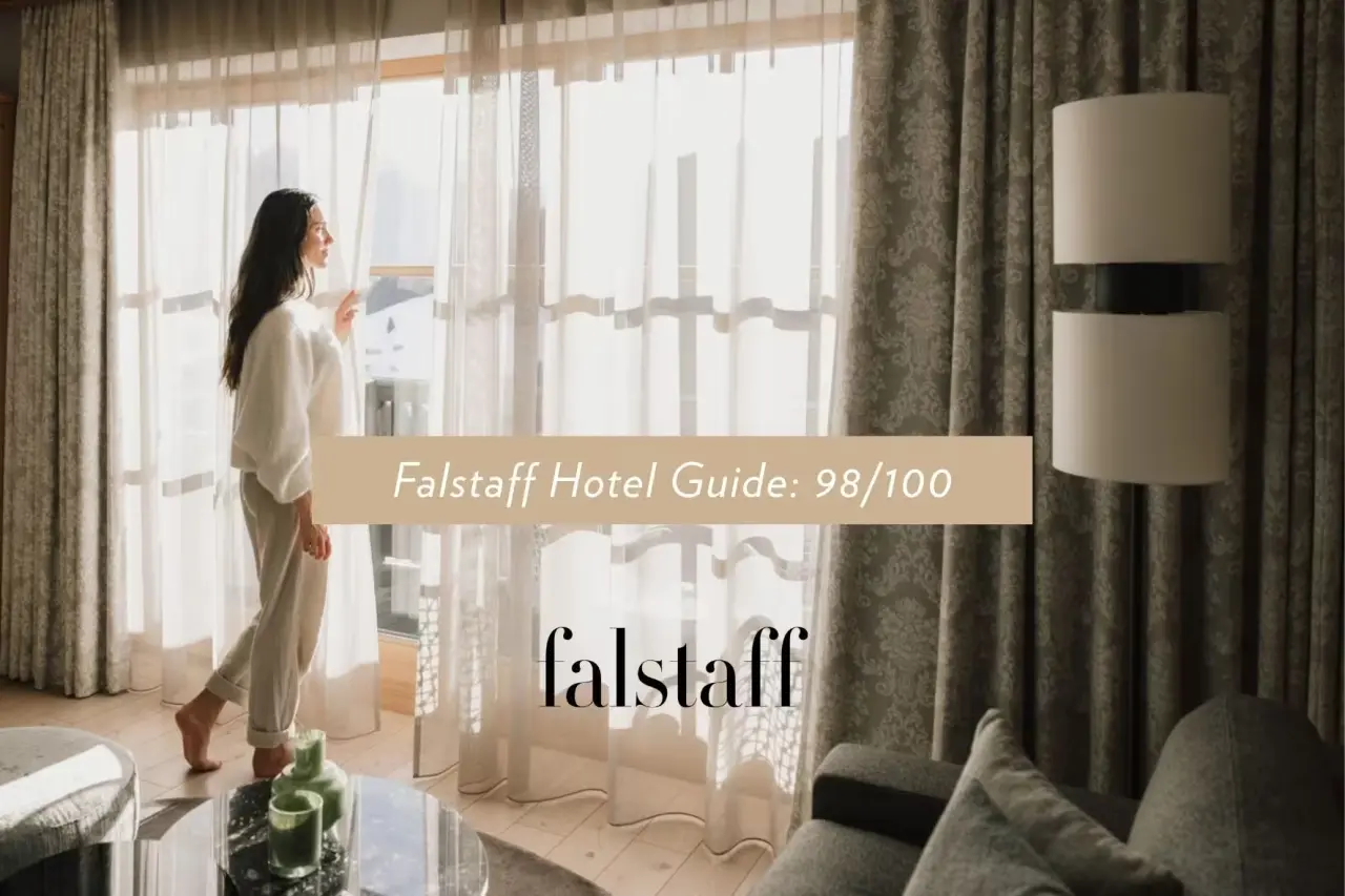 Schlosshotel Fiss in Fiss – Frau blickt aus dem Fenster eines komfortablen Hotelzimmers | Wellnesshotel Tirol
