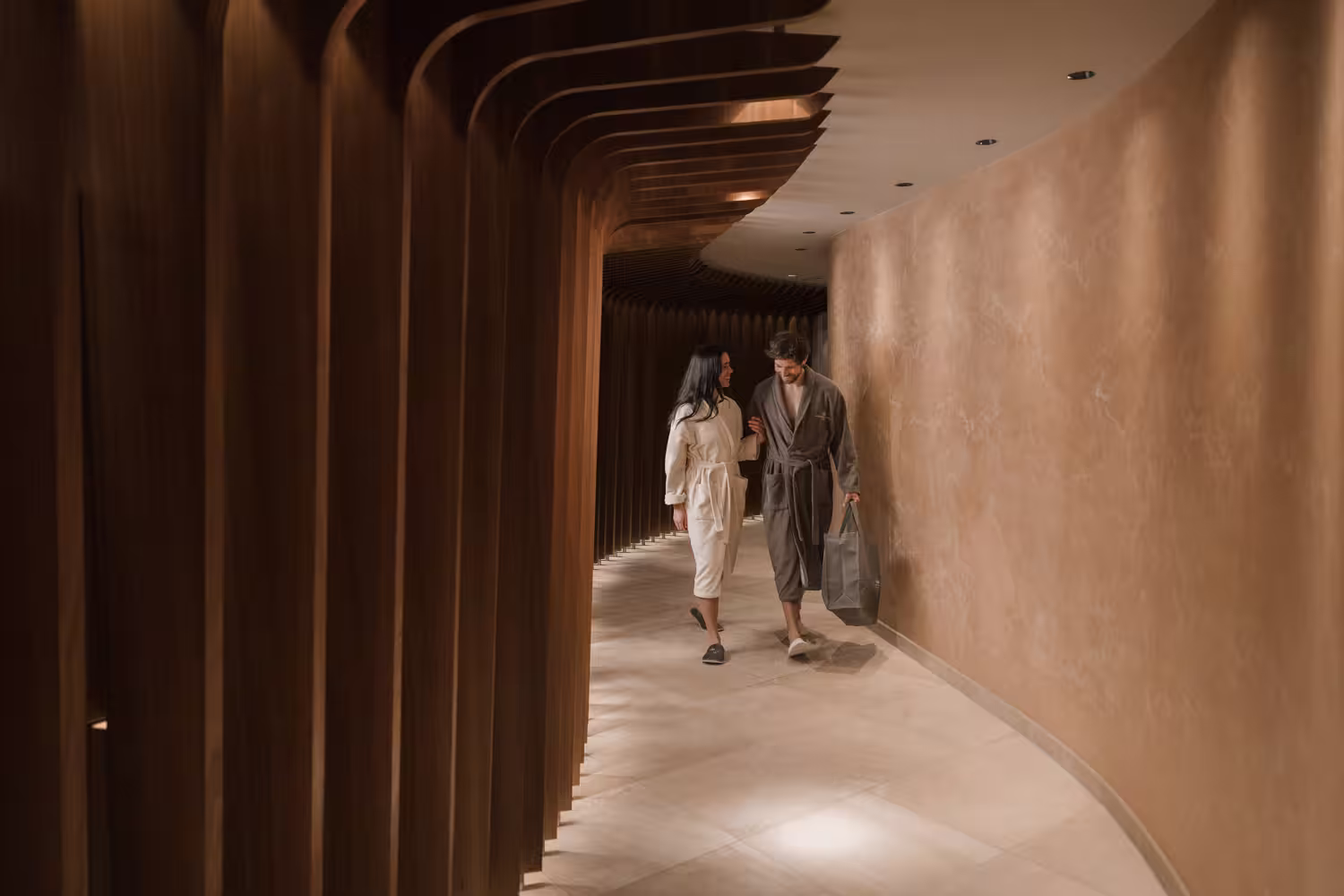 Schlosshotel Fiss in Fiss – Paar in Bademänteln auf dem Weg zum luxuriösen Spa-Bereich | Wellnesshotel Tirol