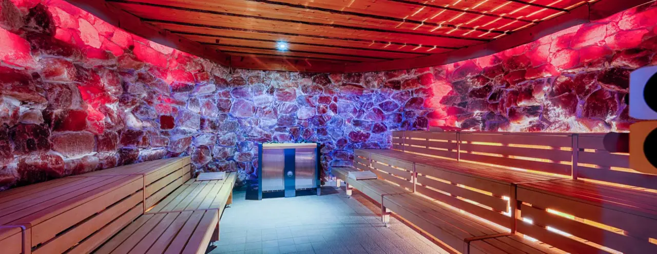 Moderne Salzsauna mit farbiger Beleuchtung und Holzliegen im Wellnessbereich des Welcome Hotel Bad Arolsen.