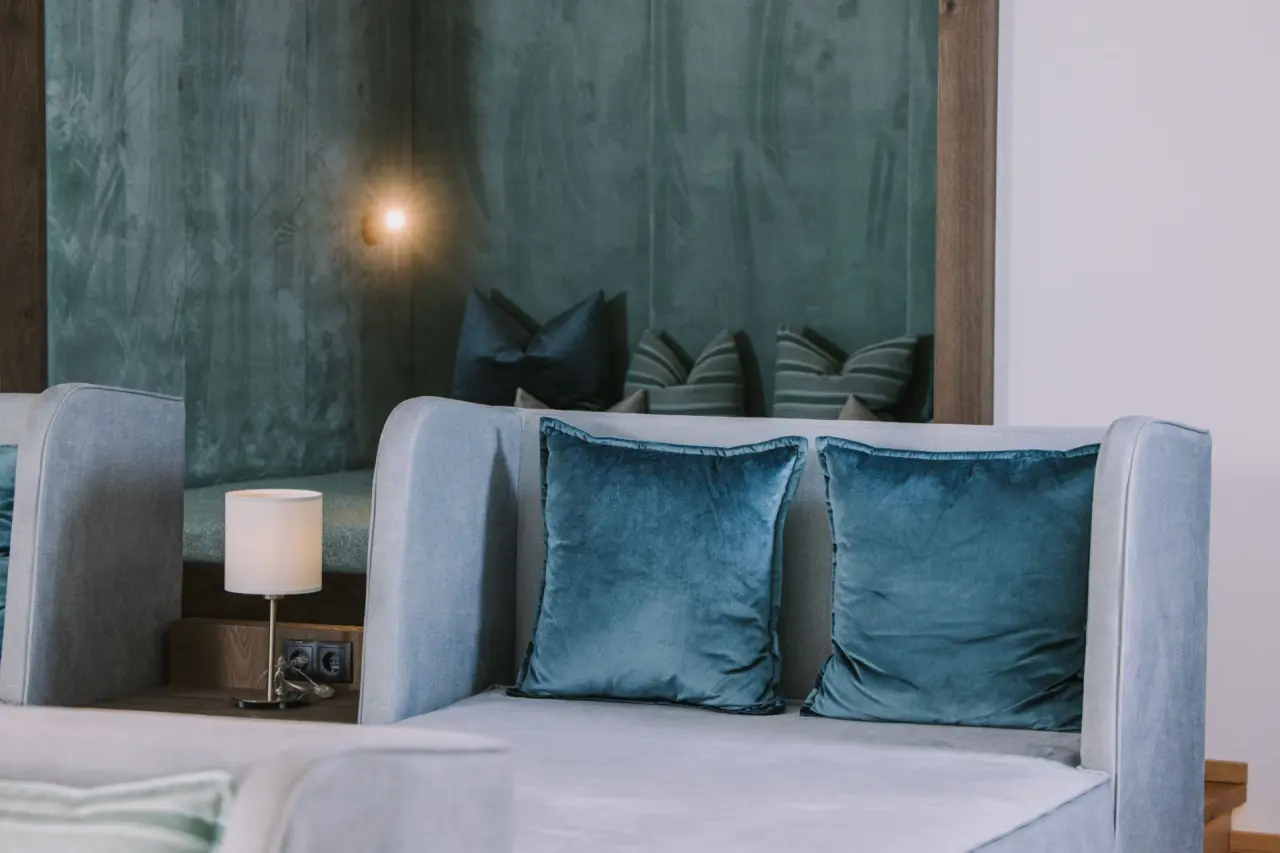 Stilvolle Sitzecke mit blauen Samtkissen und indirekter Beleuchtung im Landhotel Zenzerwirt.