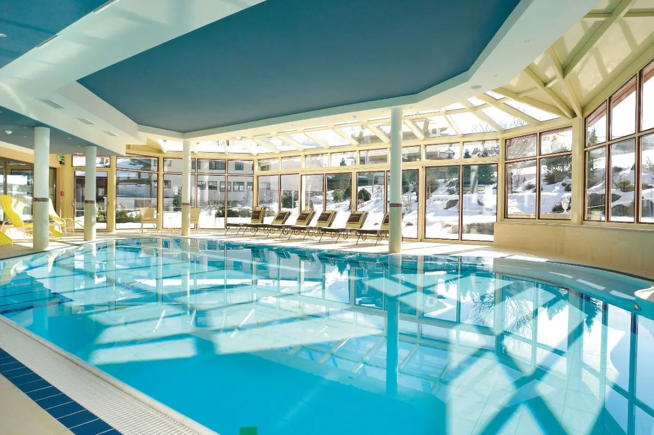 Beheizter Innenpool im Landhotel Zenzerwirt mit grossen Fenstern und Blick auf die verschneite Winterlandschaft.