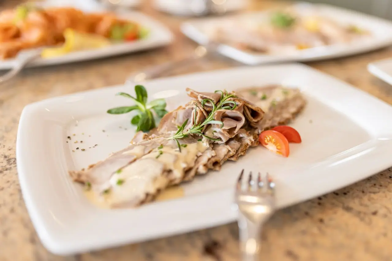 Appetitlich angerichtetes Gericht mit Fleisch, Sauce und Rosmarin im Restaurant des Landhotel Zenzerwirt.