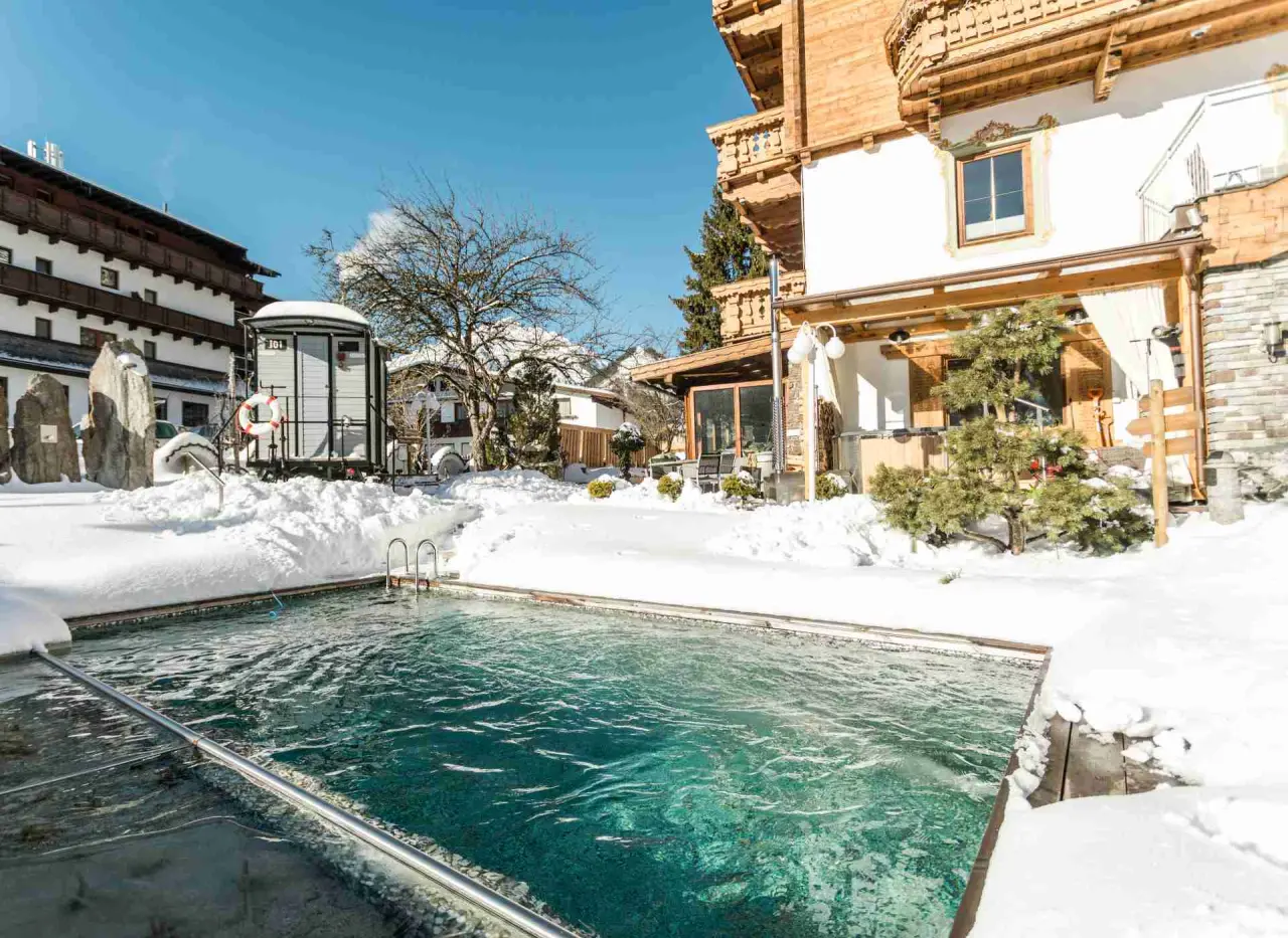 Beheizter Aussenpool im Schnee mit Blick auf das Alpenhotel Tyrol am Achensee. Winter-Wellness-Erlebnis.