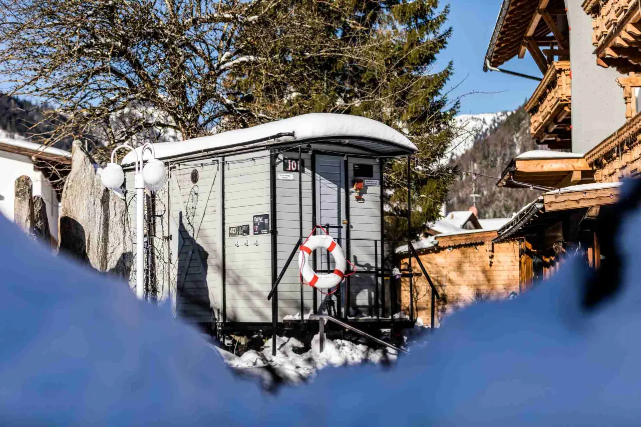 Einzigartiges Waggon-Zimmer '101' im Schnee mit Bergblick im Alpenhotel Tyrol am Achensee.