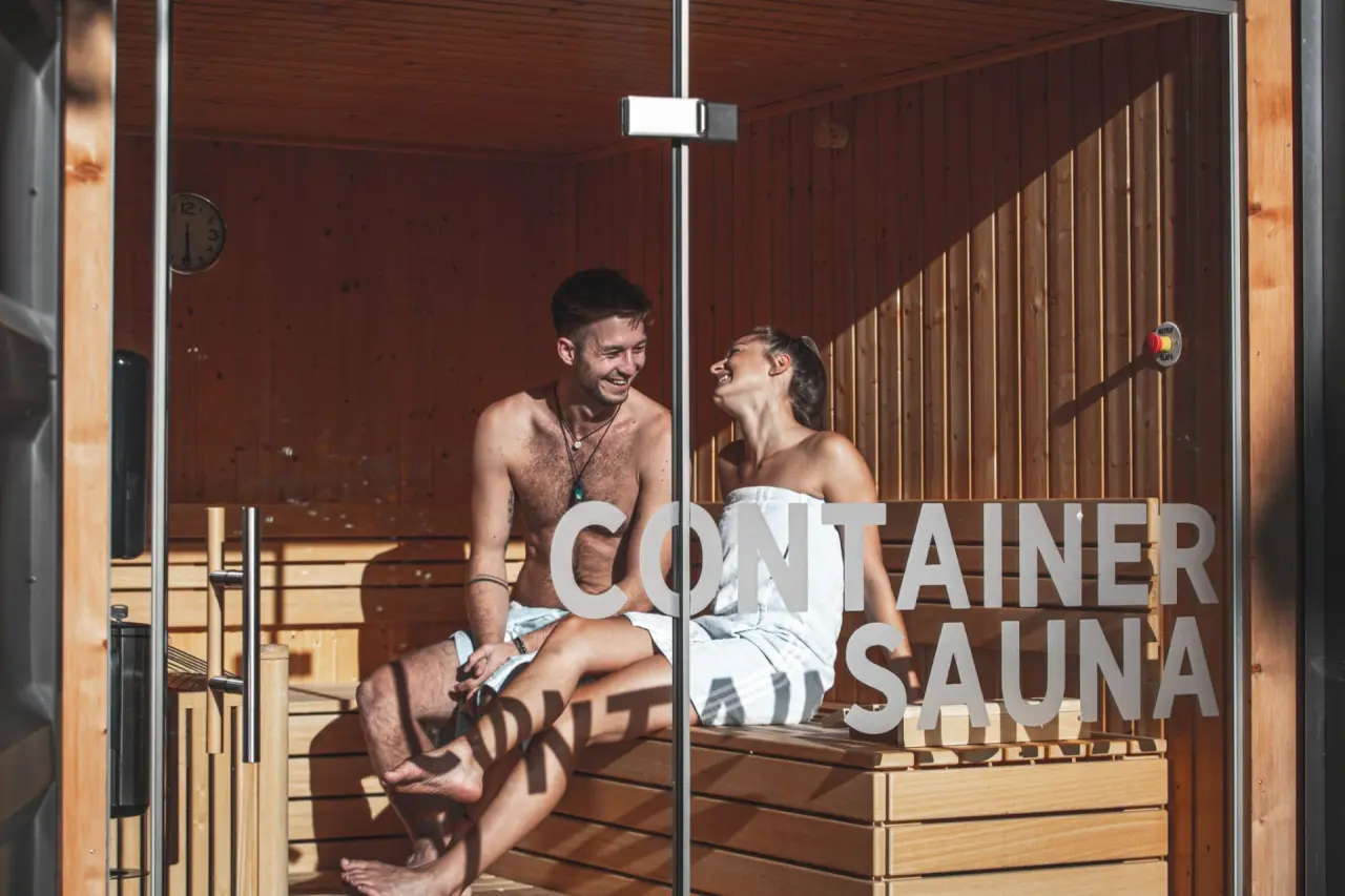 Glückliches Paar in der modernen Container Sauna des Alpenhotel Tyrol am Achensee.