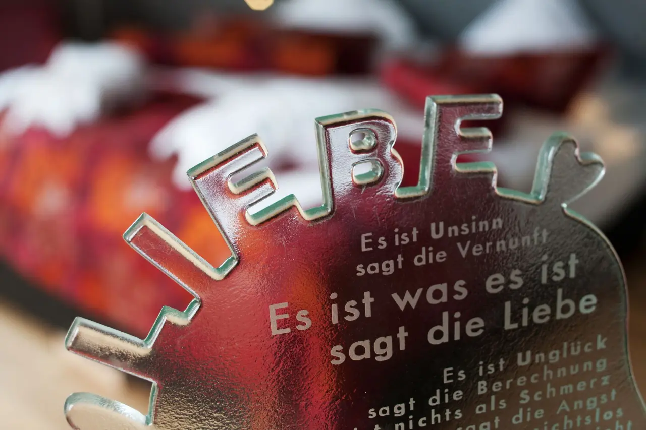 Dekoratives Glasobjekt mit dem Wort 'LIEBE' und philosophischem Text im Hotel Pabst.